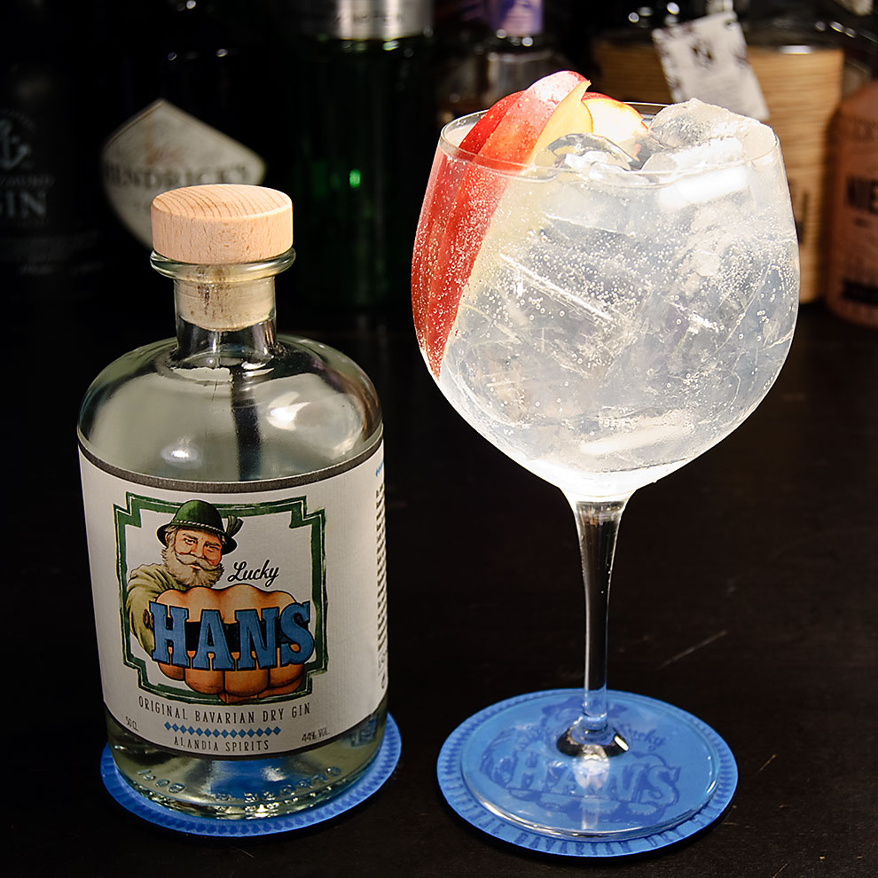 Un gin tonic Lucky Hans est mélangé avec des toniques classiques et garni d'un quartier de pomme. 