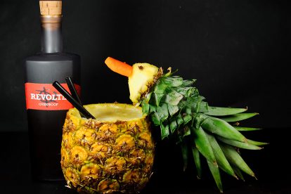 Revolte Overproof Rum in einer Pina Colada, serviert in einer Ananas, garniert mit einem Ananas-Schnabeltier.
