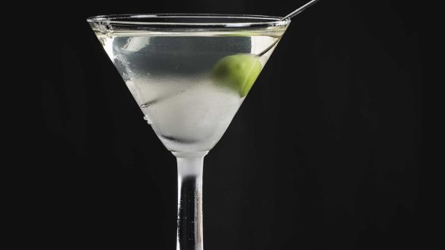 Ein trockener Martini, garniert mit einer einzelnen Olive.