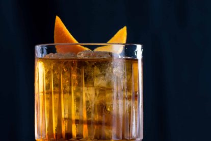 Ein Old Fashioned Cocktail mit Bourbon Whiskey, Bitters, Zuckersirup und Orangenzeste.