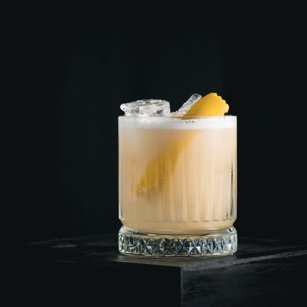 Ein klassischer Whiskey Sour Cocktail mit Eiweiß.