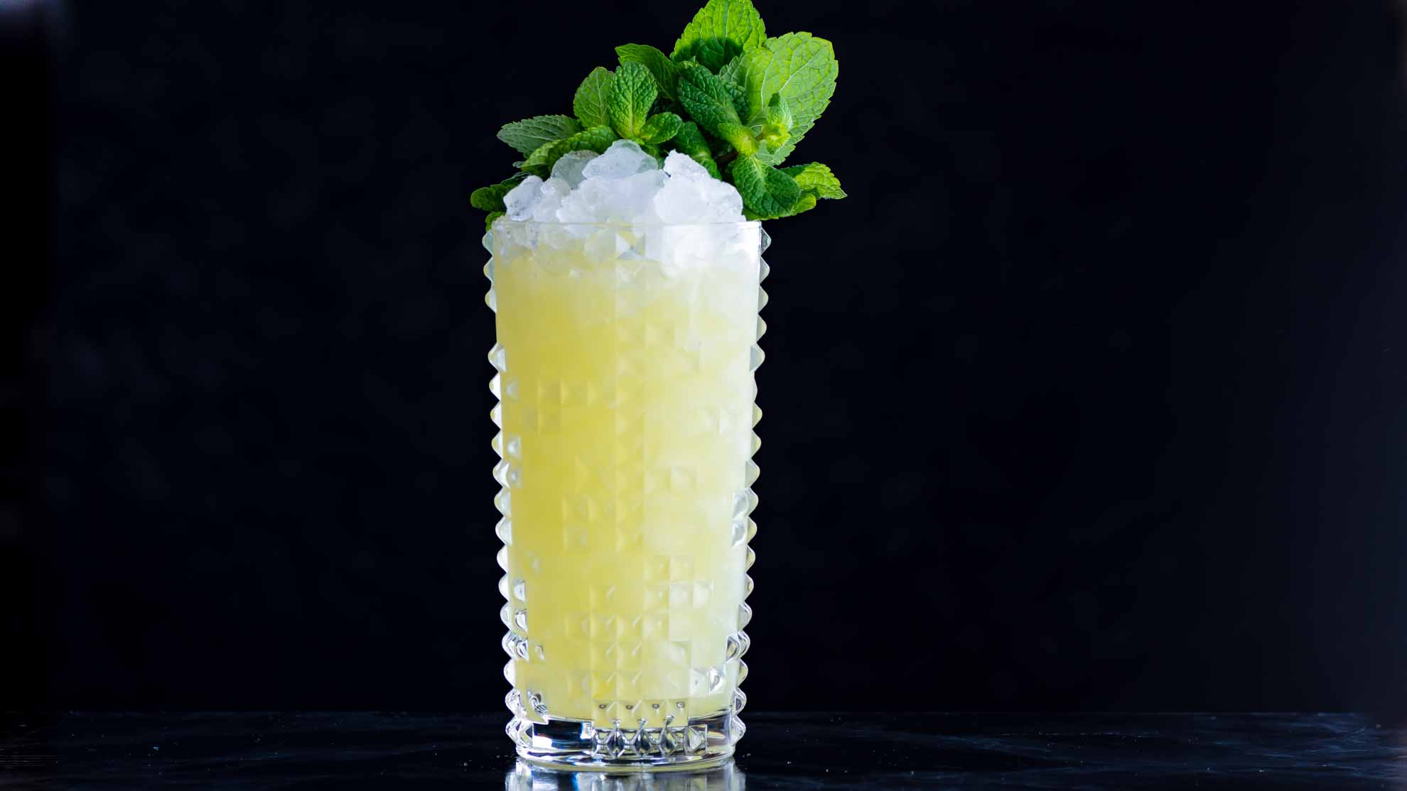 Le Cocktail Swizzle Chartreuse avec Chartreuse, Falernum et jus d'ananas.