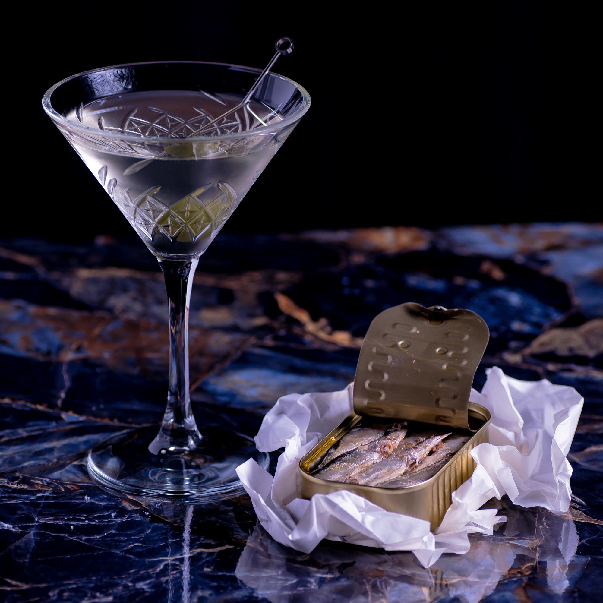 Ein Martini mit einer Dose Jahrgangssardinen.