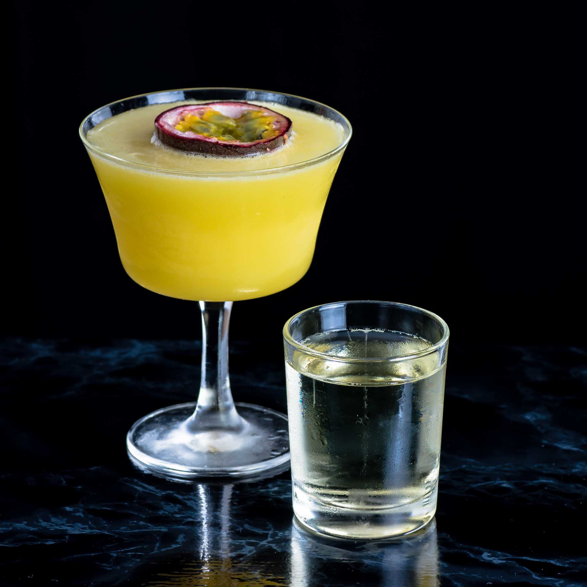 Un martini Porn Star composé de fruits de la passion, de vodka, de sirop de vanille et d'un shot de champagne.