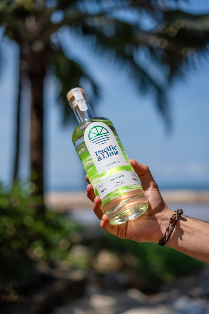 Eine Flasche Pacific & Lime Tequila am Strand.